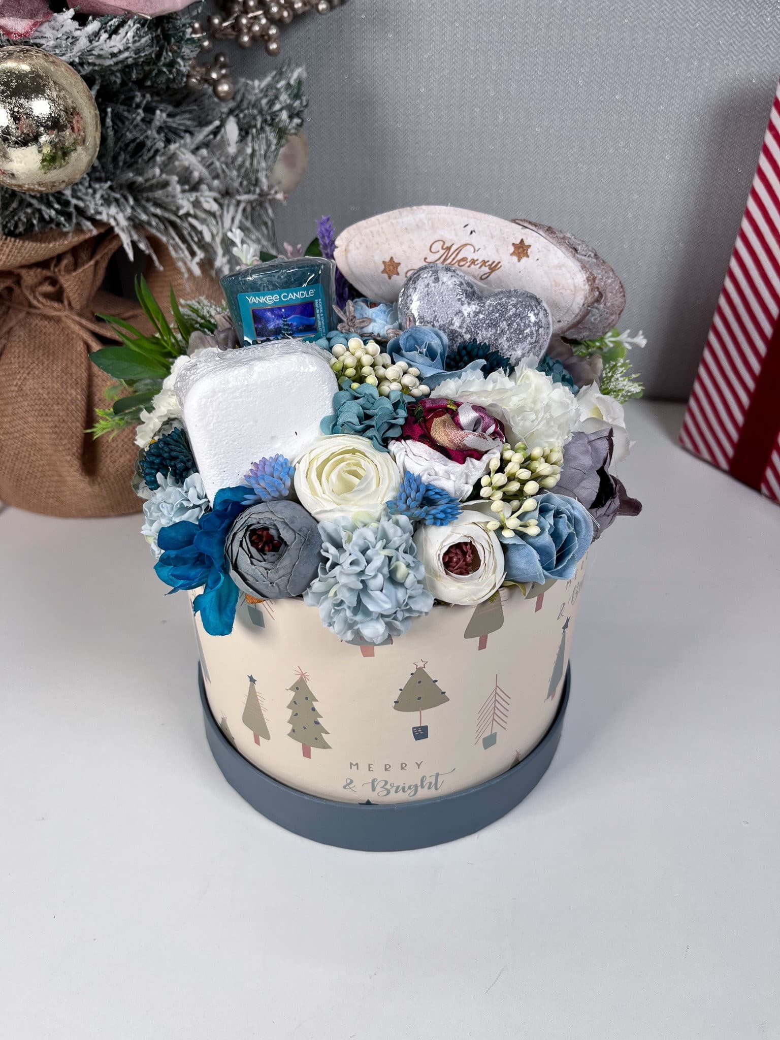 Personalised blue christmas box with artificial floral display and pamper items inside. Gift includes
Bath Bomb
Shower steamer
Headband
Yankee Candle