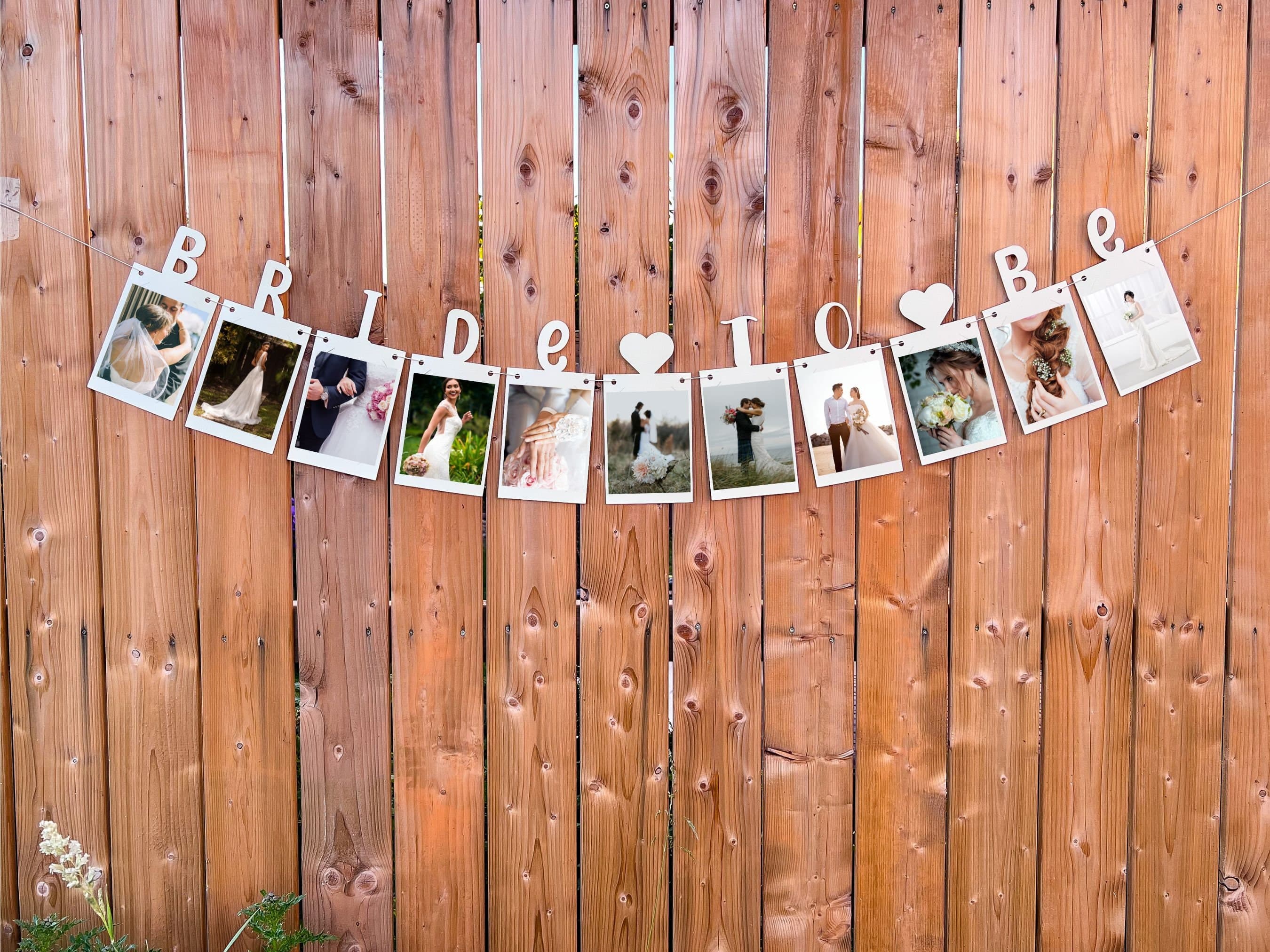 This is a card stock banner that spells out βbride to beβ. This banner contains slits where photos of the bride can easily be inserted. It comes prestrung.