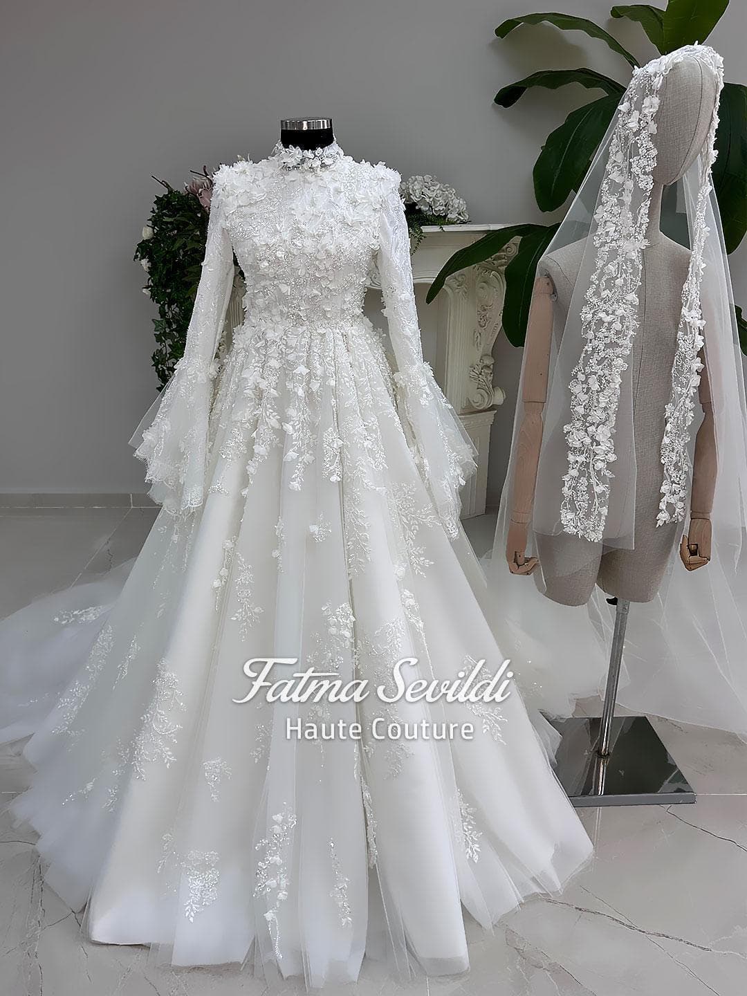 Veiled hijab wedding dress in a modest A-line silhouette with high neck, long sleeves and floral appliqué, custom made for luxury Muslim bridal coverage. Includes a matching lace veil for a complete bridal set.