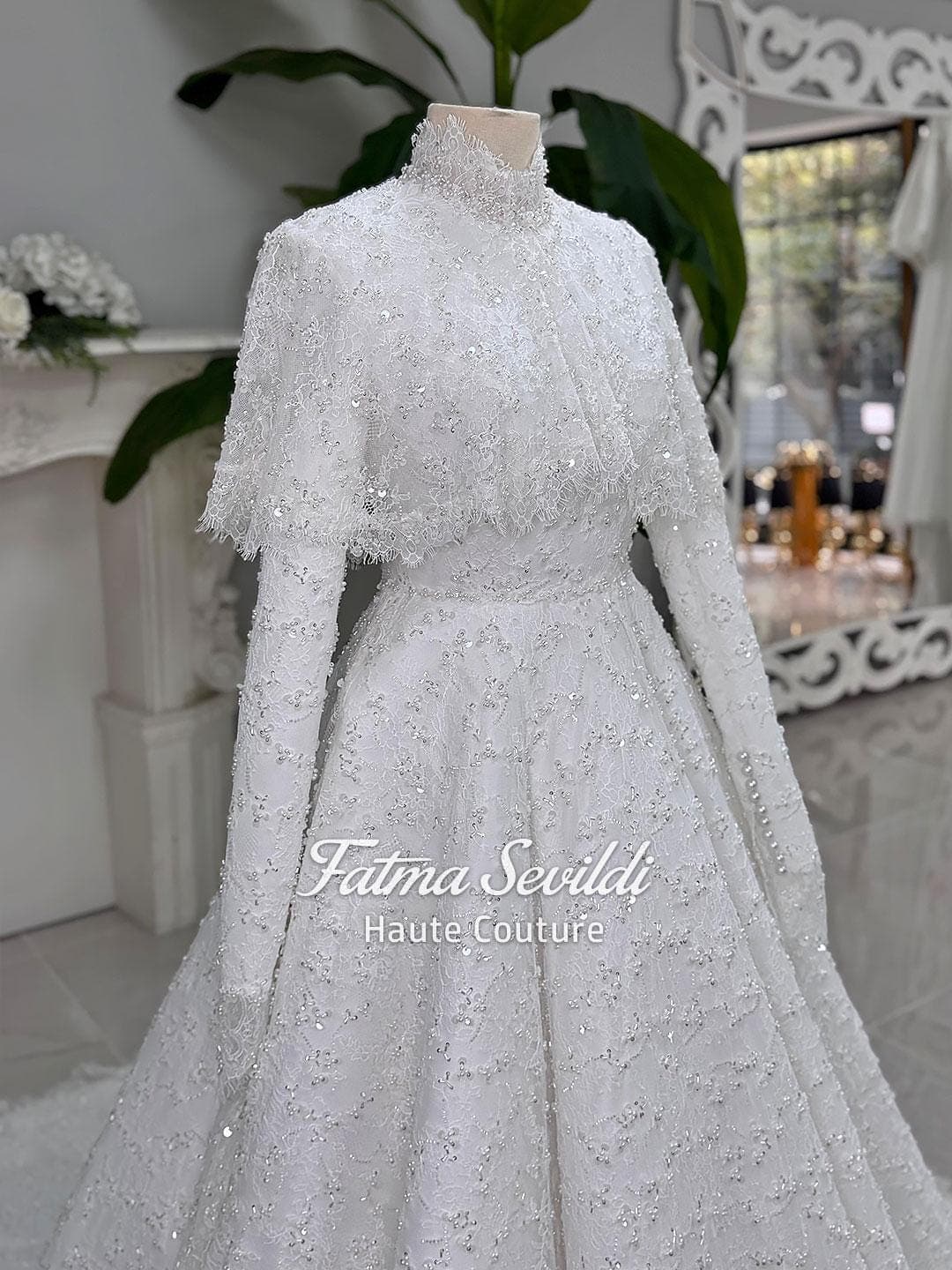 Veiled hijab wedding dress with high neck, long sleeves, and shimmering beaded lace in an elegant A-line silhouette. Includes premium lace veil, headscarf, and a lace short cape for a complete modest bridal set.