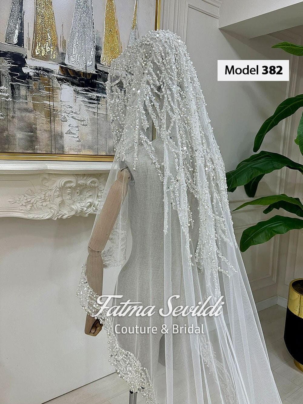 Beaded lace mantilla bridal veil in soft ivory tulle with cathedral-length drape, designed for elegant wedding styling and modest hijab-friendly wear. Long lace edge wedding veil with refined hand-finished detail and timeless bridal coverage.