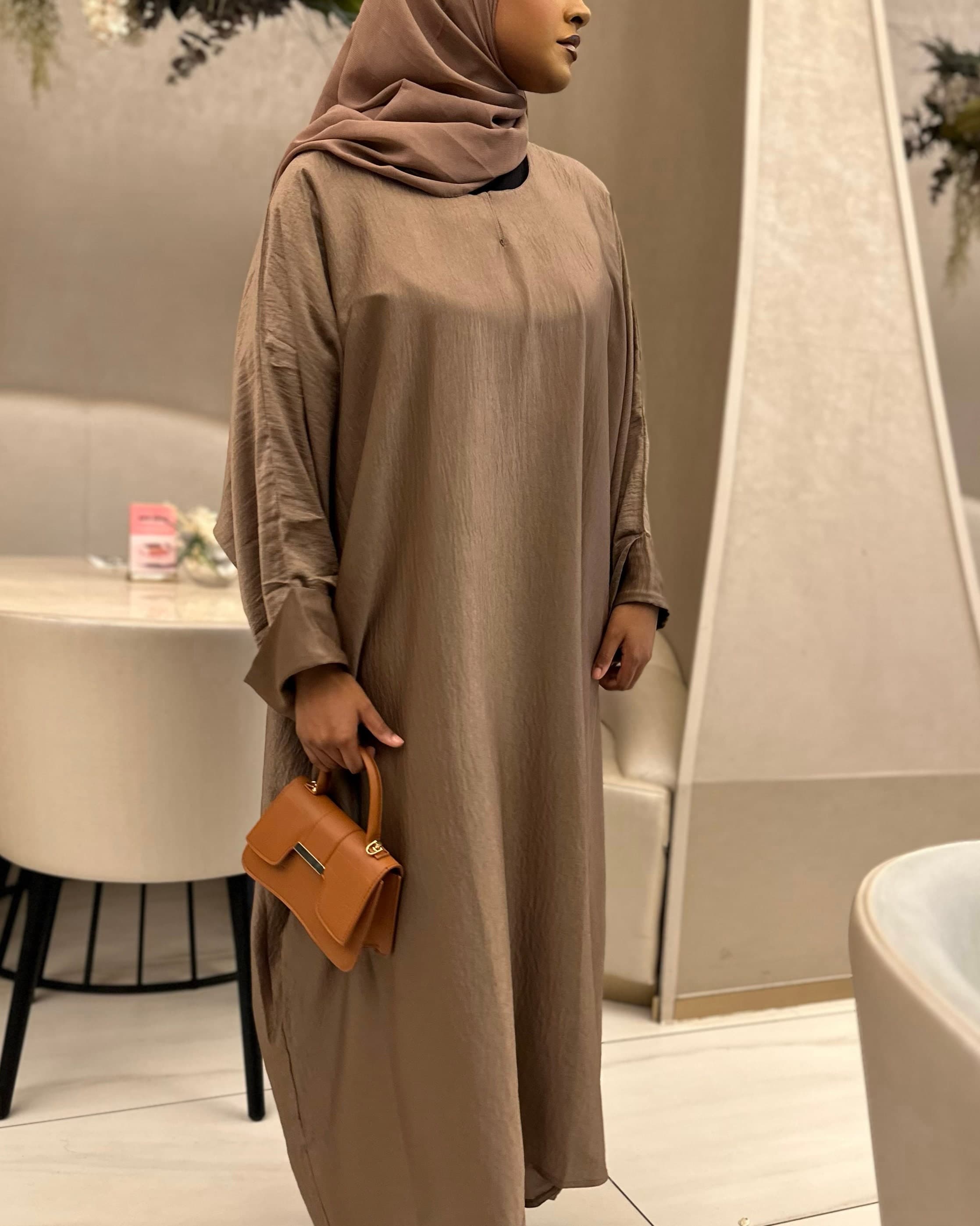 Chocolate brown abaya with long sleeves, loose fit design, breathable lightweight umrah clothing.