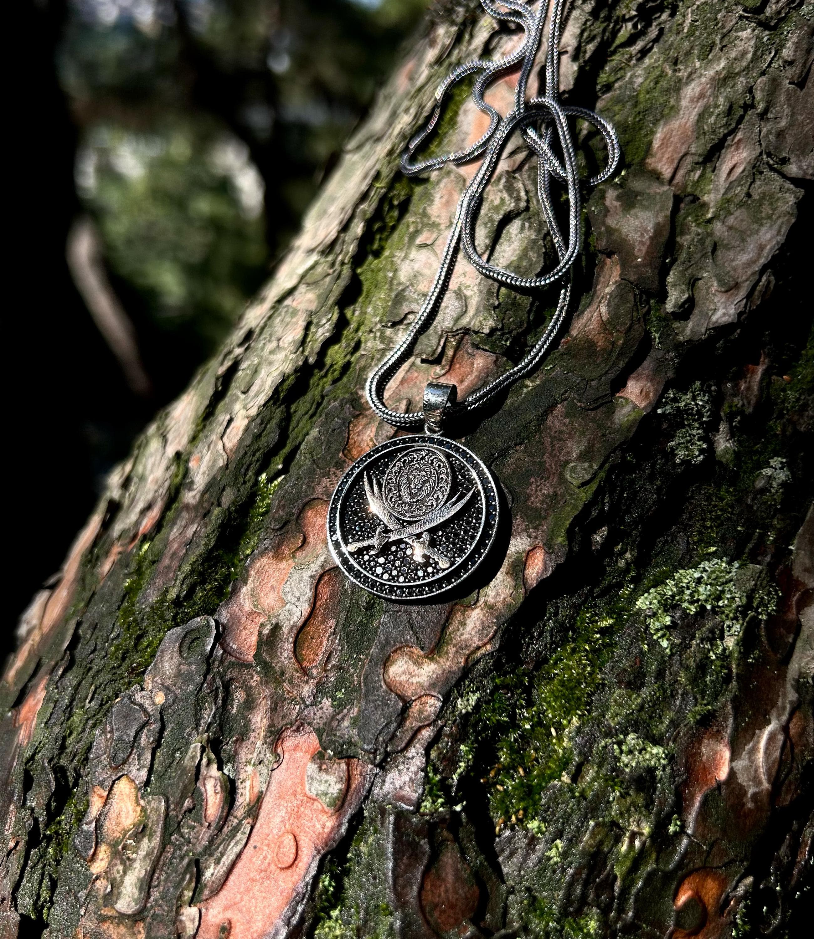 925 sterling silver necklace with Zulfikar sword and lion head motif, placed on a dark textured surface, reflecting Islamic warrior spirit and handcrafted detailing.