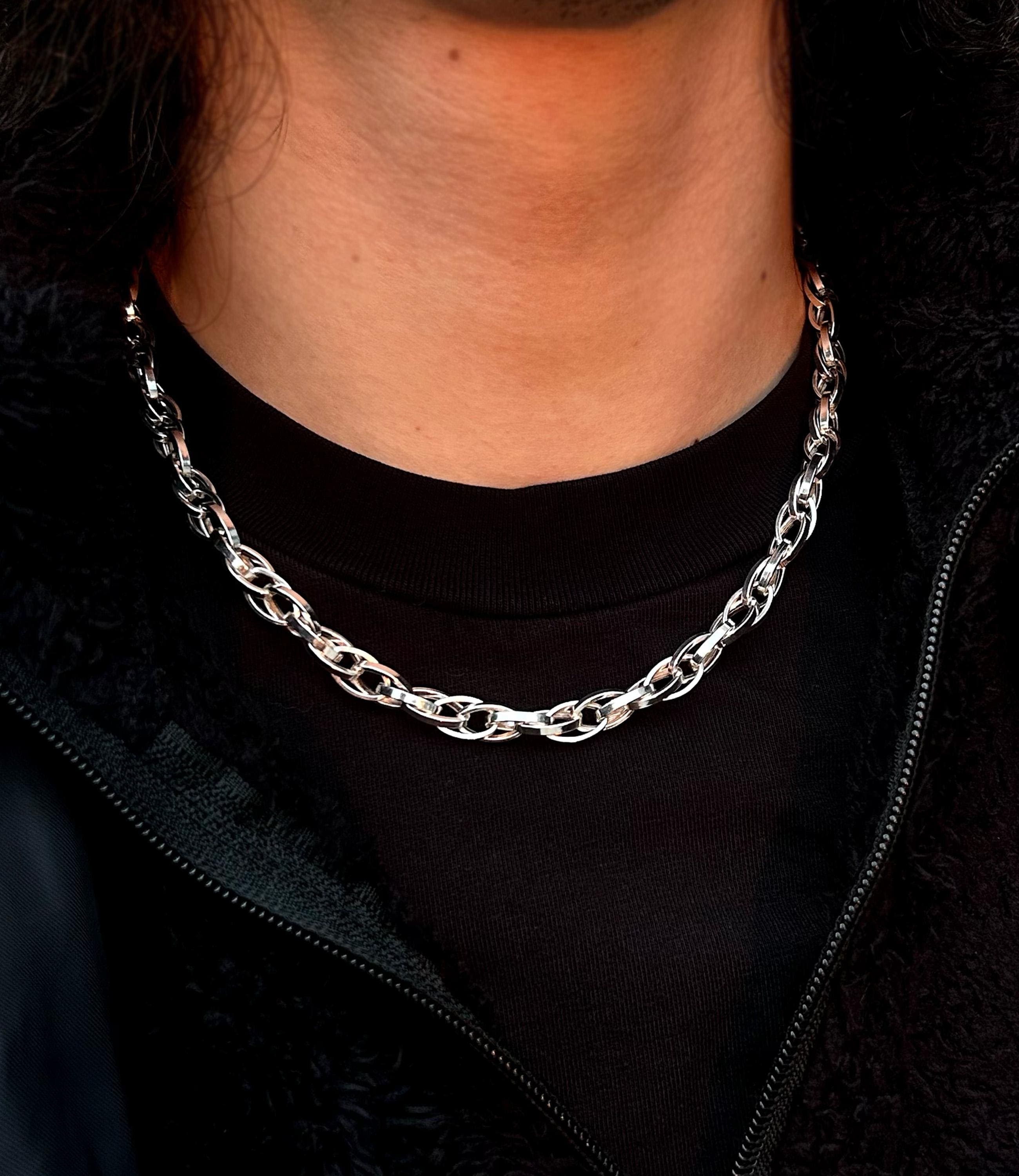 A unique 925 sterling silver paperclip necklace with complex, interlocking oval links, draped to show its intricate woven texture and high-polish finish.