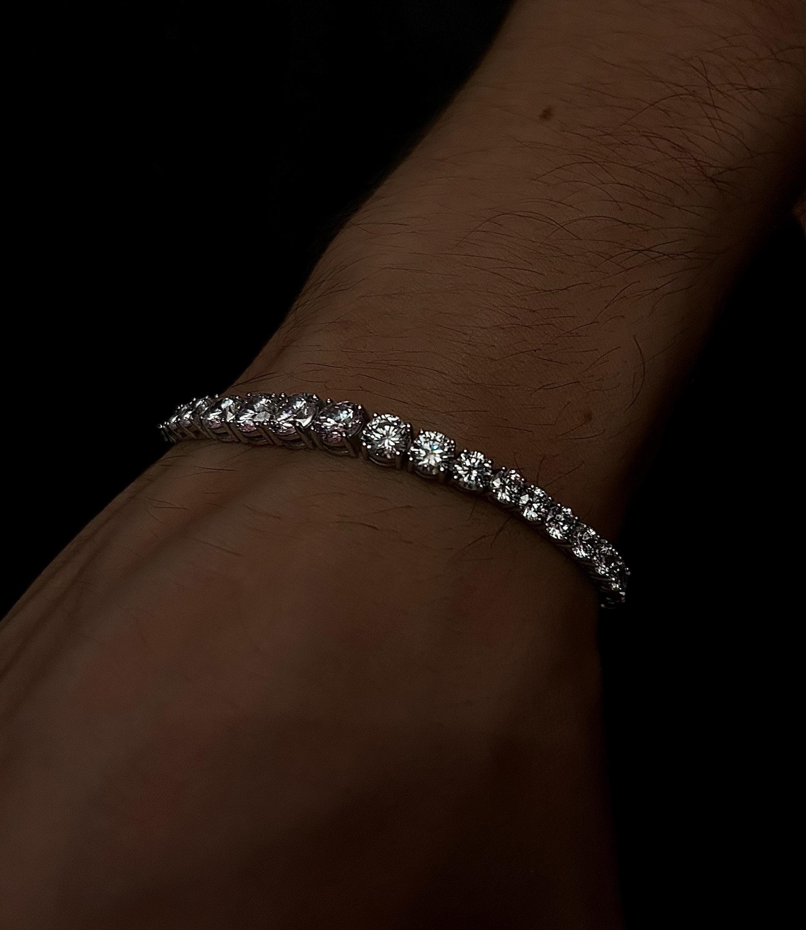 925 sterling silver tennis bracelet featuring gradually increasing CZ stones, laid on a soft neutral background to highlight its handmade sparkle and elegant design.