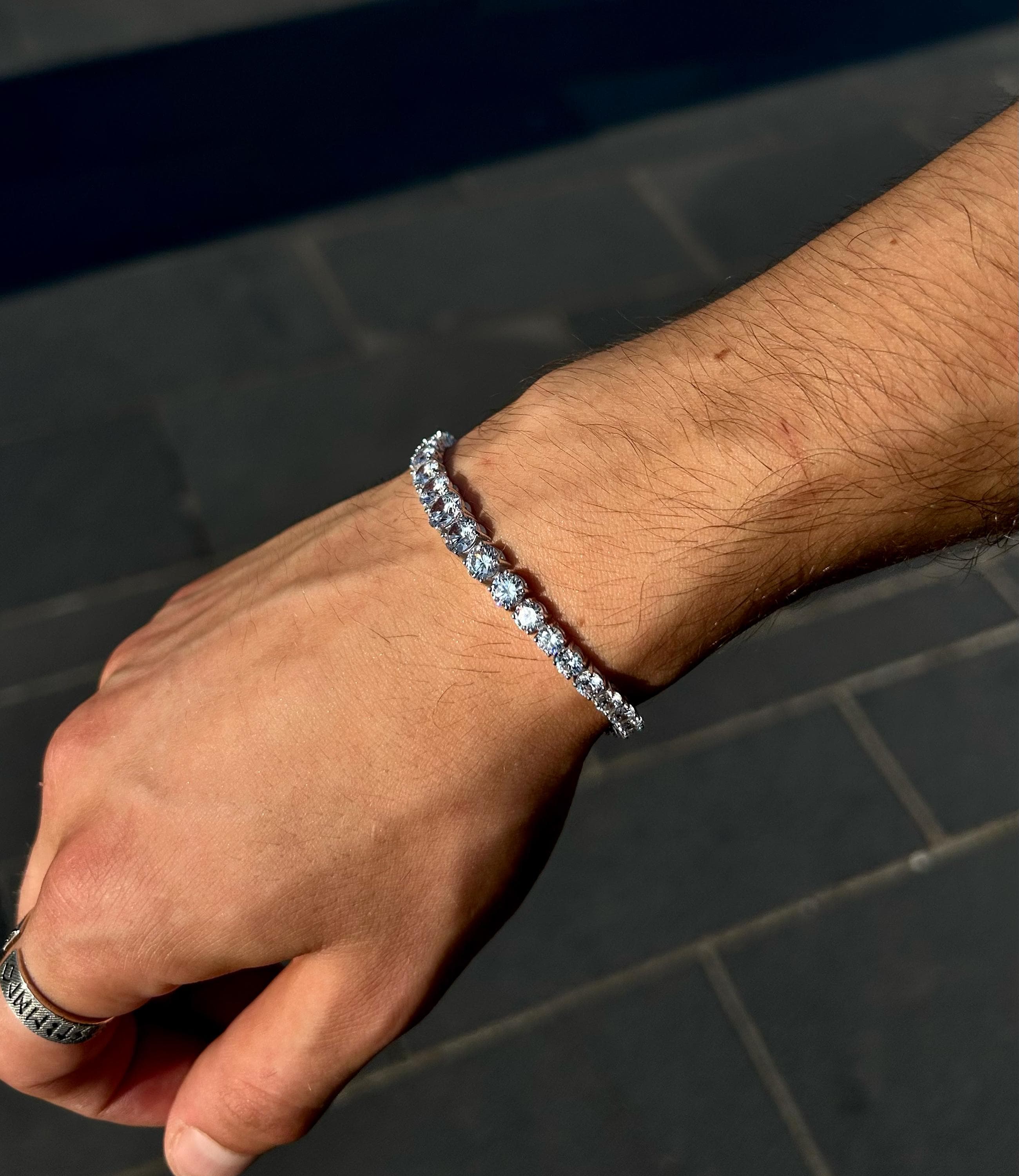 925 sterling silver tennis bracelet featuring gradually increasing CZ stones, laid on a soft neutral background to highlight its handmade sparkle and elegant design.