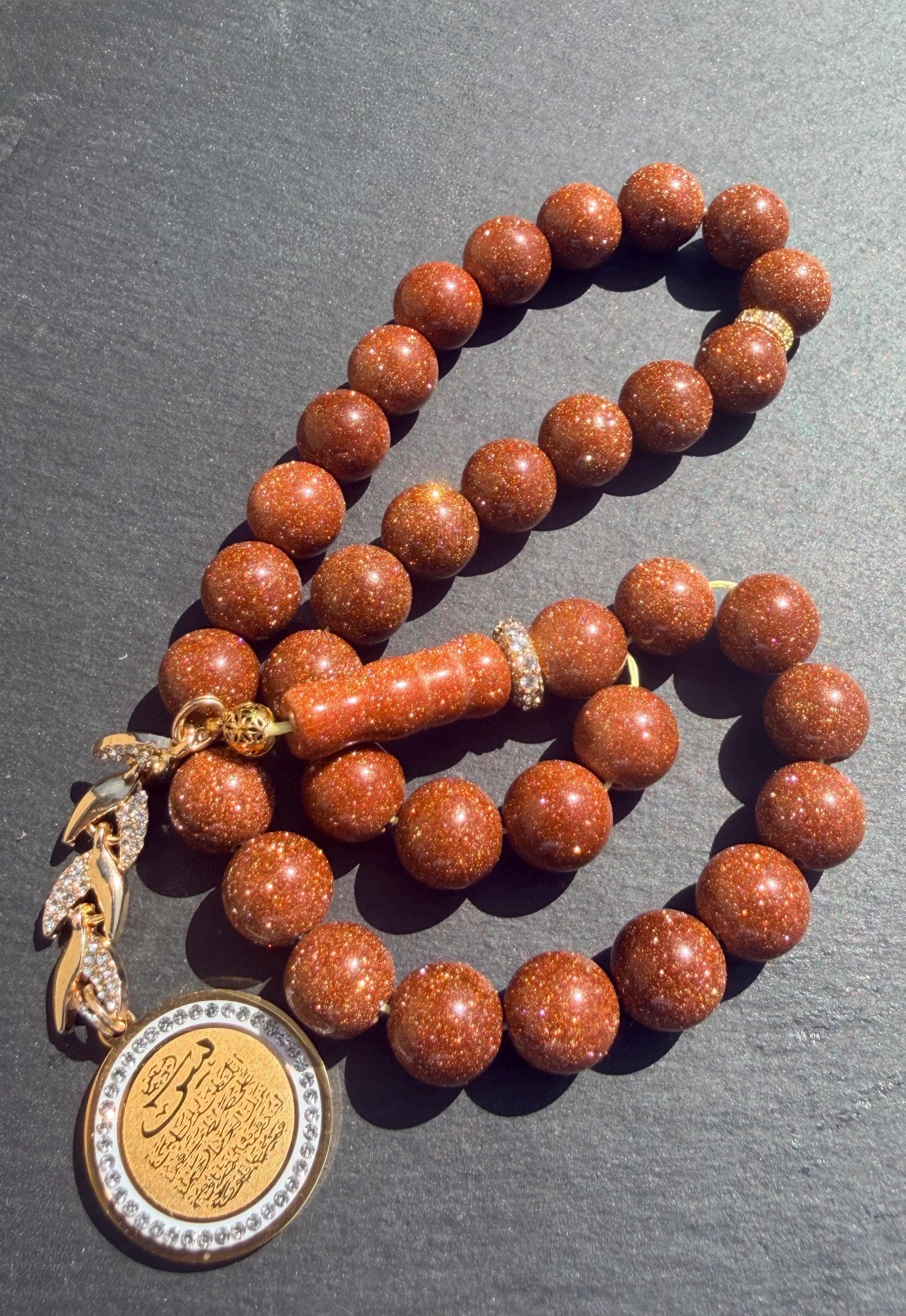 Gold Sandstone Tasbih, gold plated medal in the tassel with Yasin Quran Verses.