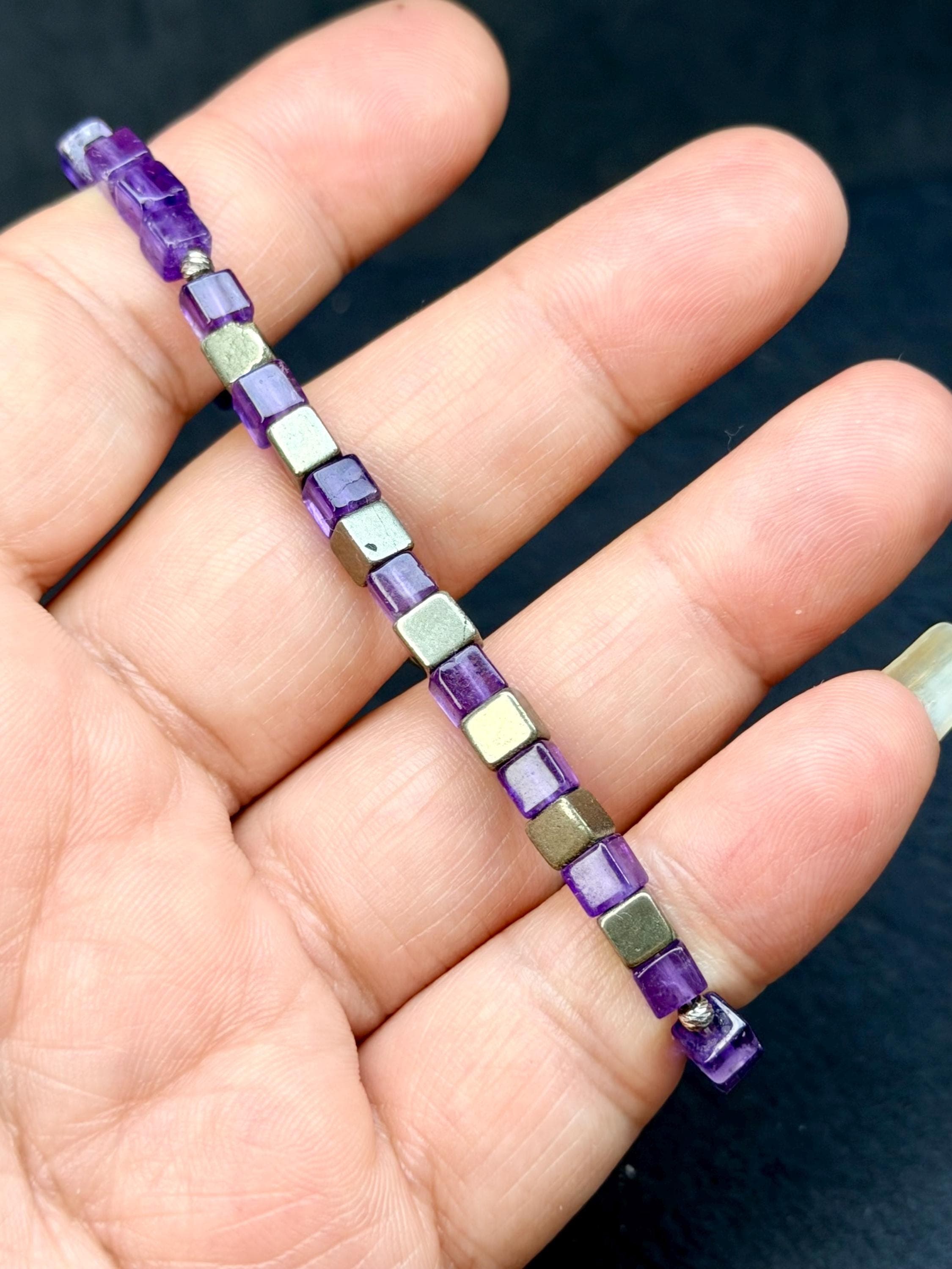 Amethyst and Pyrite Beaded Bracelet, Crown Chakra Energy Healing energy. in a hand