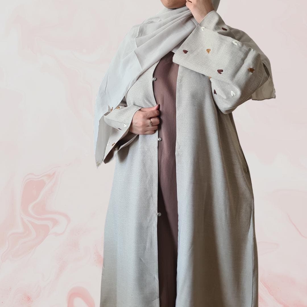 Elegant beige-grey abaya with embroidered heart designs on the sleeves, including hijab and practical pockets ā ideal for everyday wear - image 3