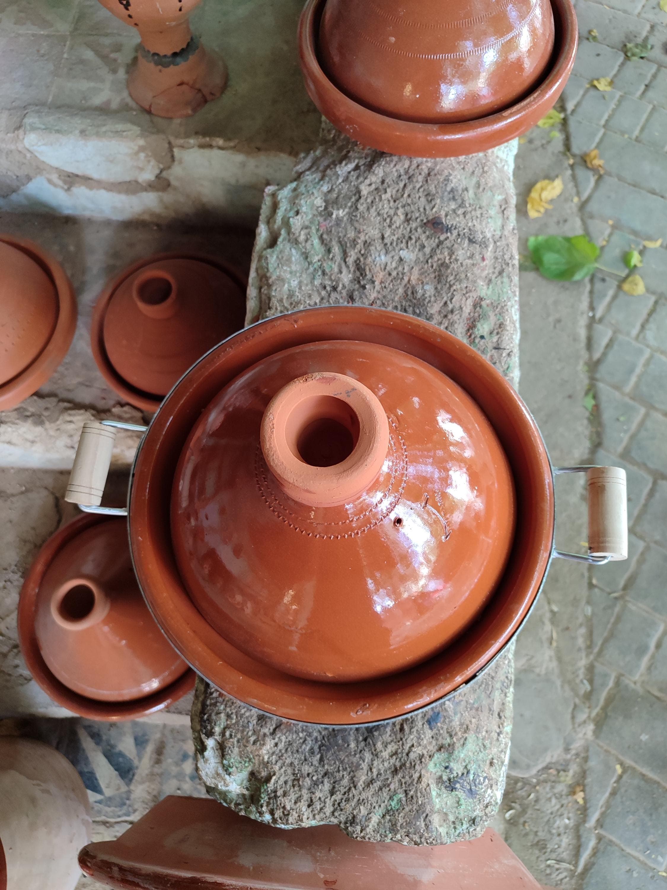 Each Moroccan tajine in our collection is individually hand-thrown by master potters using centuries-old techniques. This handmade clay tagine showcases authentic Moroccan cookware craftsmanship with its intricate geometric patterns. The medium 10" size is versatile for everyday tagine cooking. Made from locally-sourced terracotta that's been sun-dried for 30 days before firing. Unlike mass-produced alternatives, our tajine clay pots develop unique character with use.