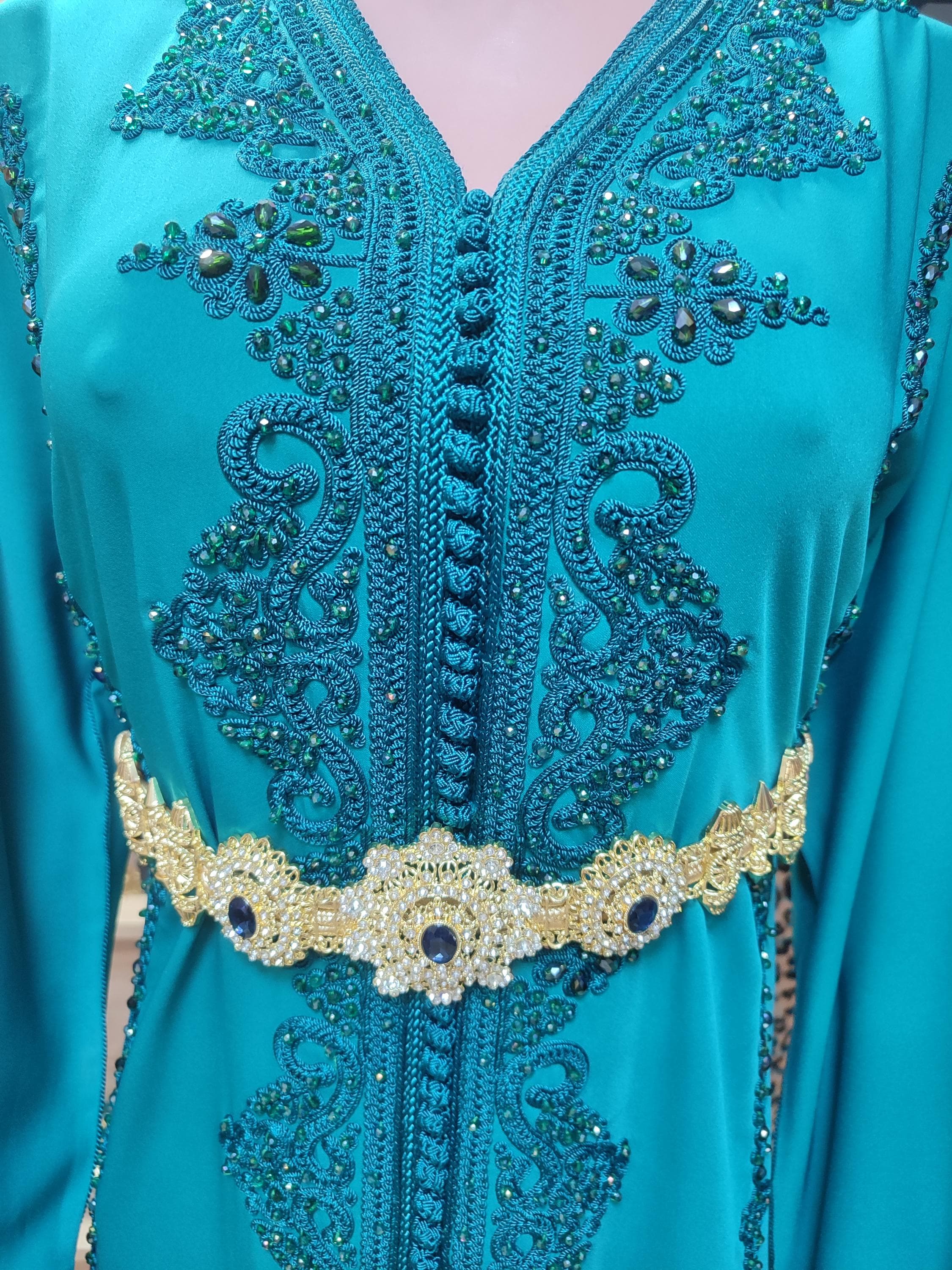 This stunning fusion ensemble combines a Palestinian dress with Moroccan takchita influences for a unique cultural statement. The thawb women's dress features traditional tatreez embroidery paired with a coordinating Arabic abaya overlay. Perfect for royal weddings, engagement parties, or cultural celebrations, this robe de ceremonie set showcases exquisite hand-stitched details. The velvet caftan accents add luxurious texture while the flowing silhouette ensures comfort.