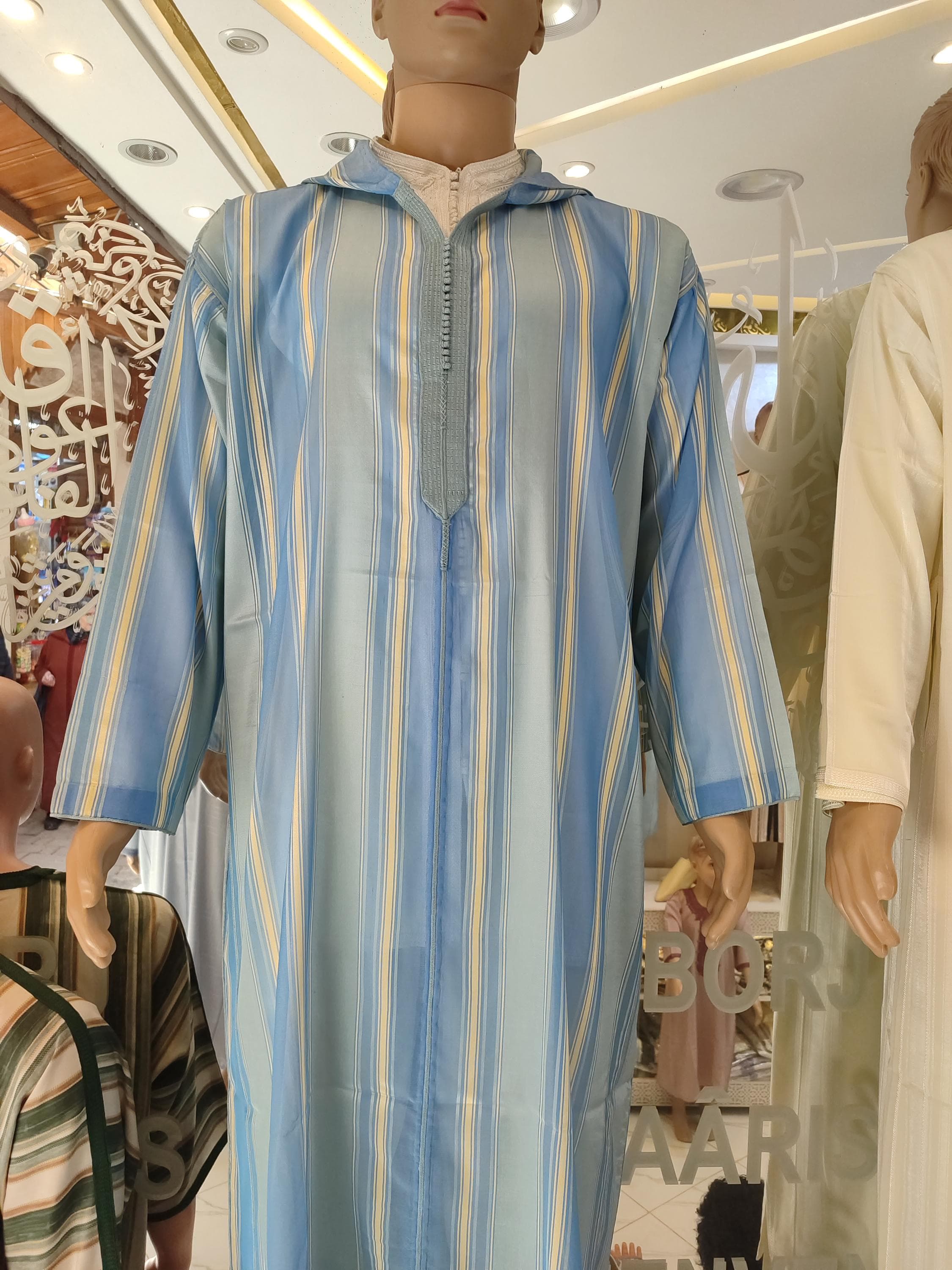 Experience authentic Moroccan fashion with this luxurious jalabiya for men. Designed with soft wool and traditional Moroccan hoodie style, this white djellaba is ideal for Ramadan evenings, Eid gatherings, or even as a Muslim wedding outfit. Combining the essence of a Moroccan kaftan, sousdi kaftan, and jubba for men, it suits both religious and festive occasions. A beautiful gift for man who appreciates quality muslim clothing, Islamic cloth, and timeless elegance.