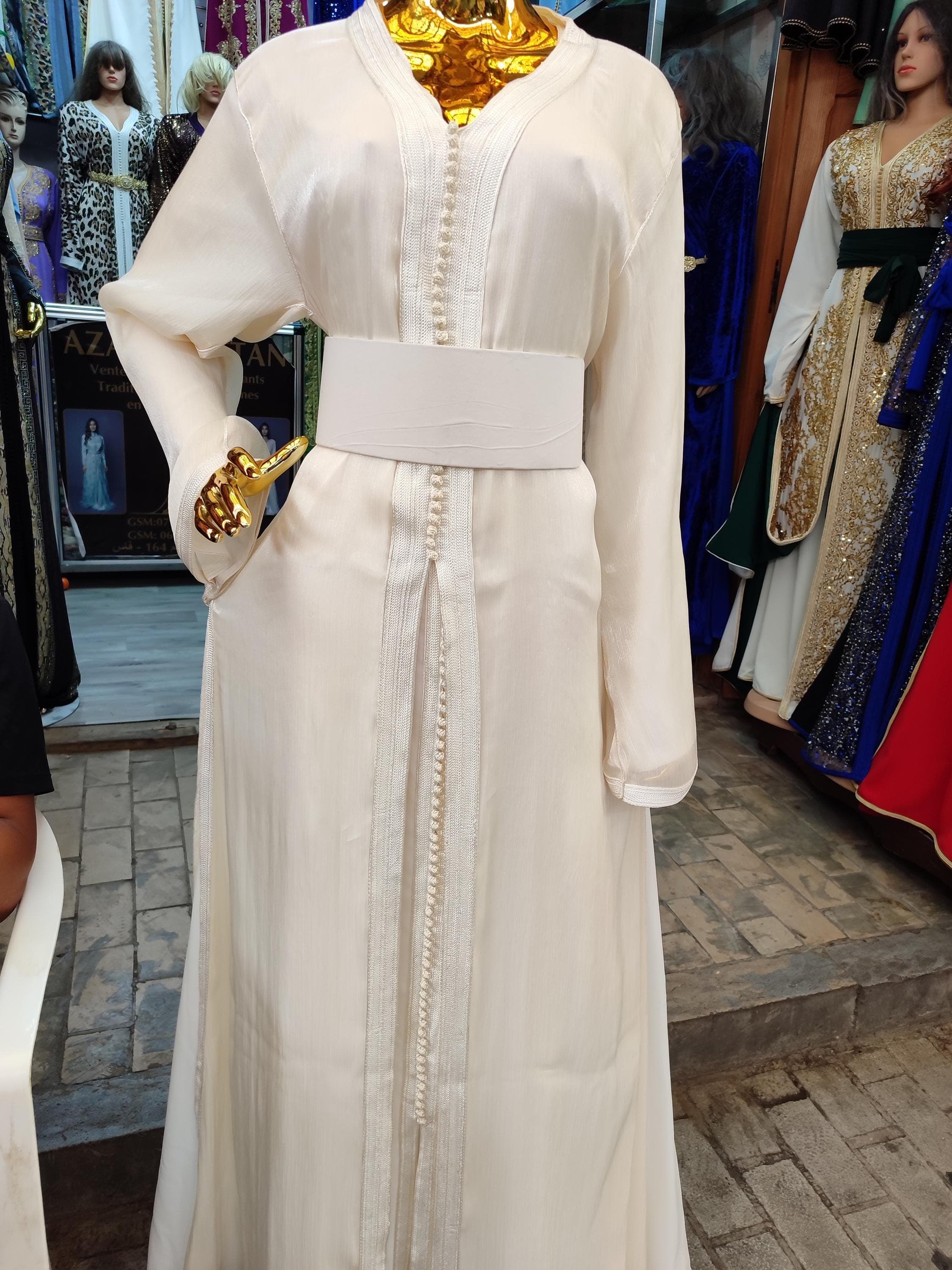This elegant white linen kaftan combines effortless sophistication with modest styling perfect for special occasions. The caftan marocain design features delicate embroidery along the neckline and cuffs, creating a refined arabic kuftan look. Made from breathable premium linen, this modest evening gown drapes beautifully while providing full coverage. Ideal for muslim wedding events, henna ceremonies, or as an arabic islamic dress for Eid celebrations.