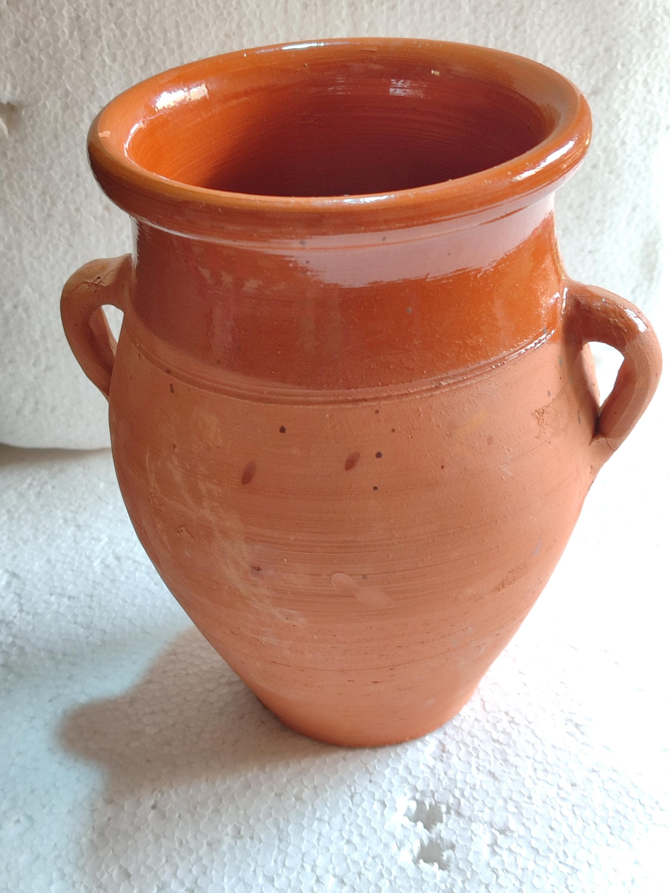 This handcrafted ceramic tangia is the perfect vessel for preparing authentic Marrakech cooking. Made from natural Moroccan clay, this Tanjia pot features a unique cylindrical design ideal for slow-cooking tender meats with aromatic spices. The thick terracotta walls retain heat beautifully, making it perfect for Moroccan stews and tagines. A must-have for lovers of North African cookware, this clay stew pot develops richer flavors with each use. Moroccan cooking pot.