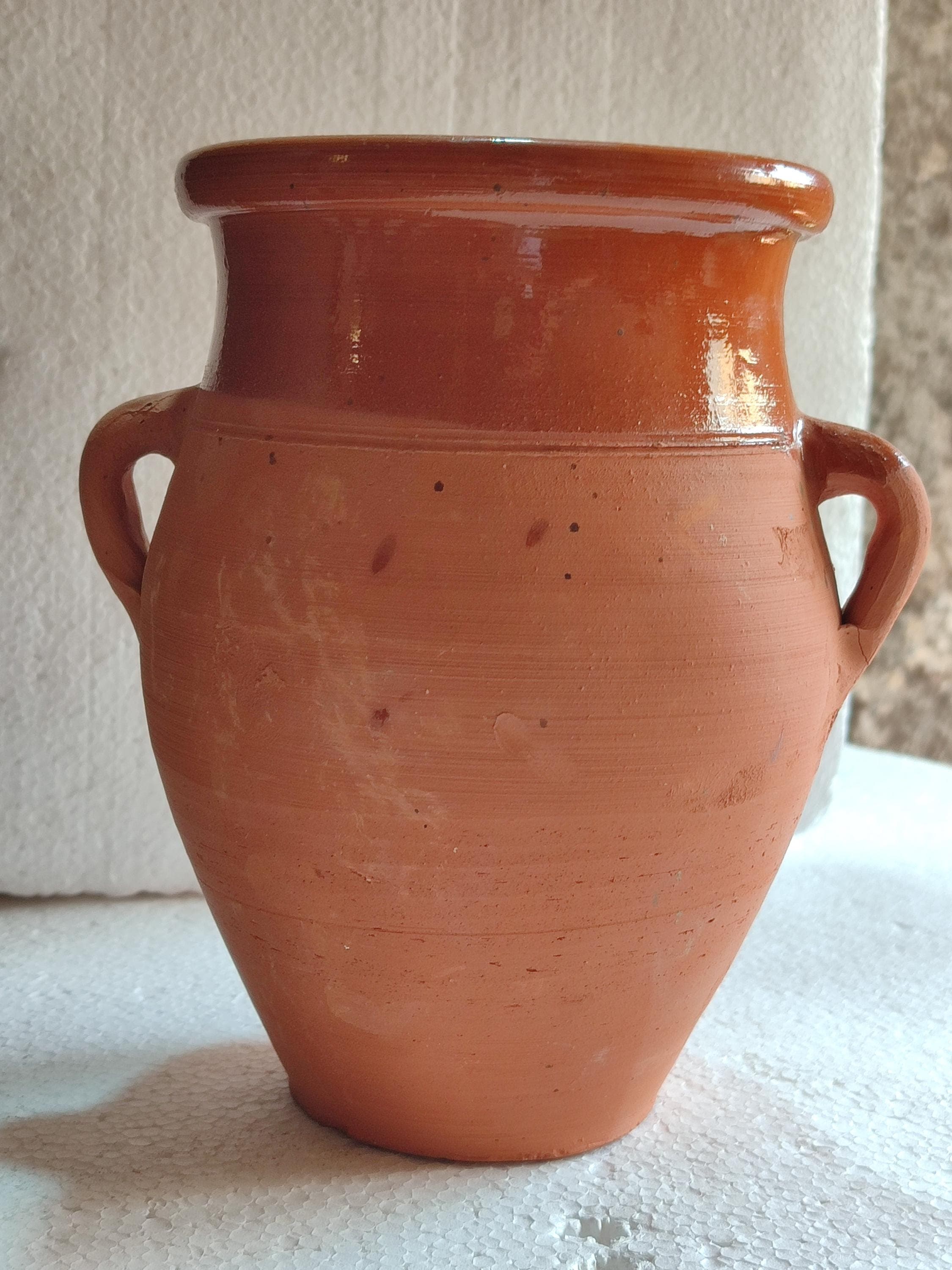 Experience authentic Moroccan cuisine with this clay Tangia, the iconic Marrakech cooking vessel. Crafted from premium Moroccan clay, this Tanjia pot is designed for slow-cooked dishes that fall off the bone. The tall, narrow shape concentrates flavors while the terracotta material ensures even heat distribution. Perfect for preparing Moroccan lamb Tangia and other slow-cooked specialties. This Moroccan cooking pot works beautifully in conventional ovens and adds rustic charm to your kitchen.