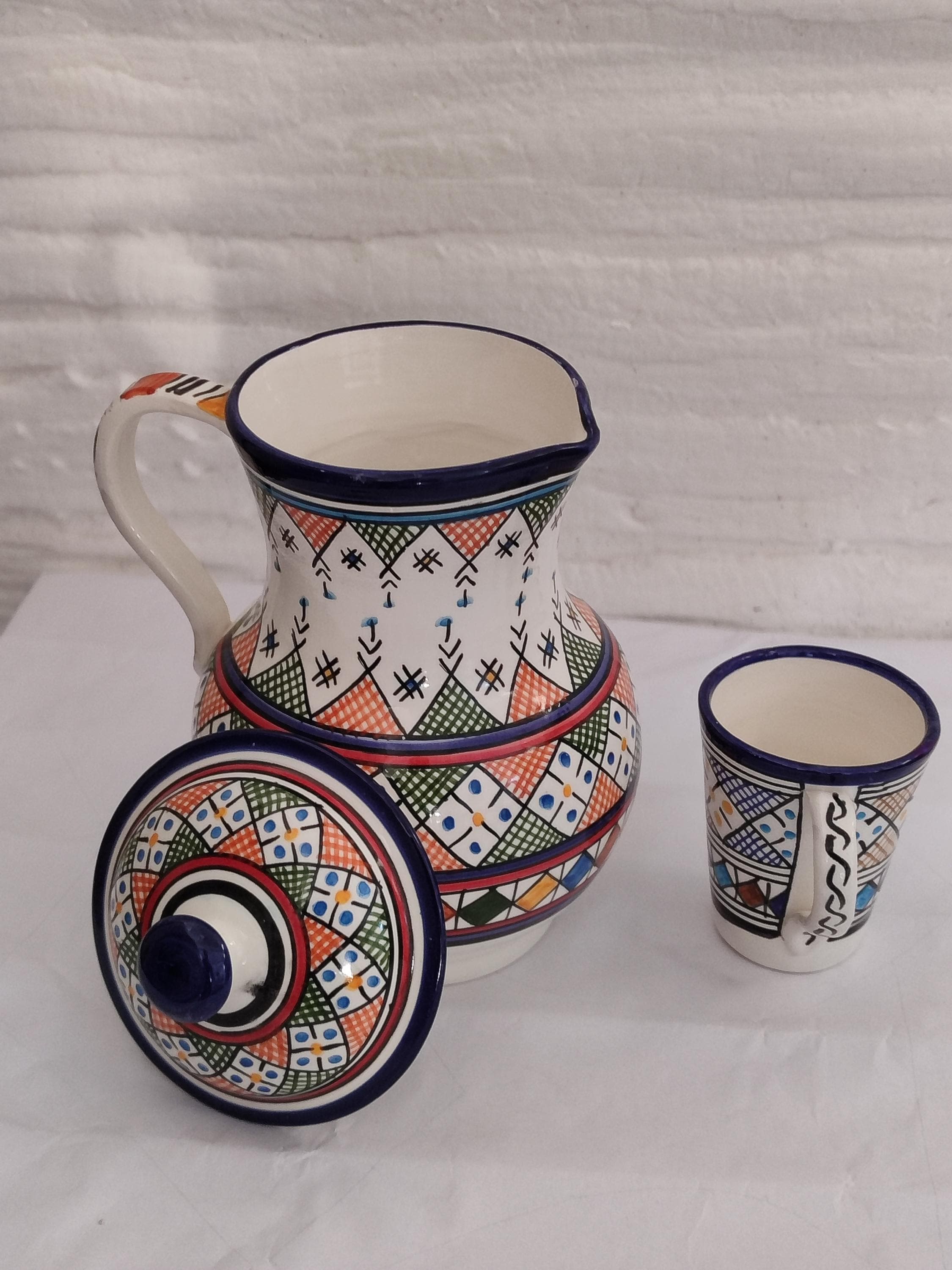 Own a unique piece of heritage with this handcrafted ceramic water carafe, a testament to true artisan pottery. Made using centuries-old techniques, this traditional water pitcher showcases the iconic style of Fez ceramics, with its complex, hand-painted geometric patterns. No two pieces are exactly alike, ensuring you receive a one-of-a-kind item. This authentic Moroccan art object is designed for both use and display, making it an exceptional piece of home decor