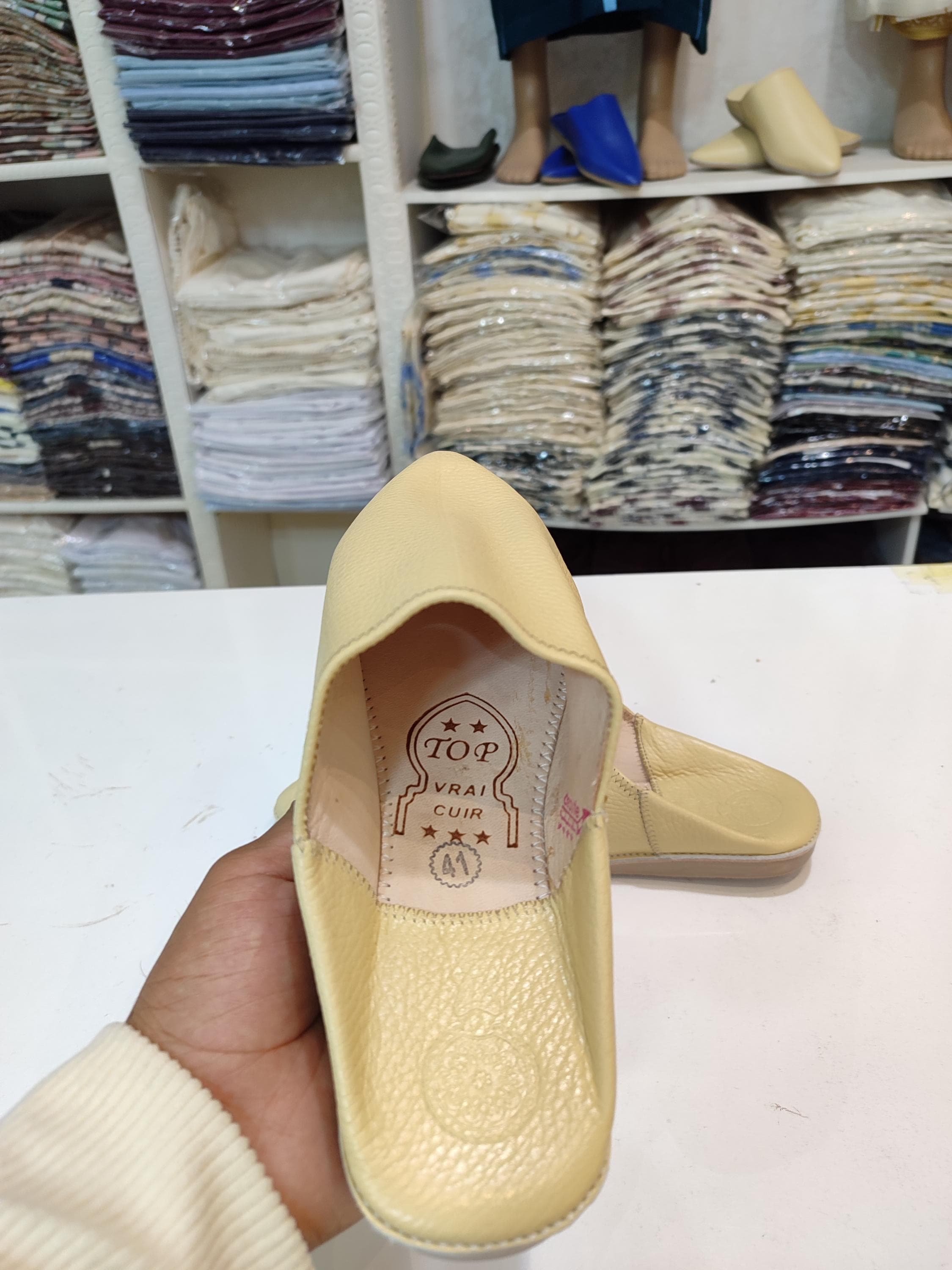 Upgrade your footwear collection with our modern babouche slippers, crafted from high-quality organic leather. These cream babouche mules feature a sleek pointed toe and a comfortable slip-on design, making them ideal for everyday wear. Inspired by the timeless appeal of Moroccan slippers, they are perfect for pairing with henna dress outfits or caftan for nikah. The neutral beige shade ensures they complement any attire, while the handmade details highlight their authenticity.
