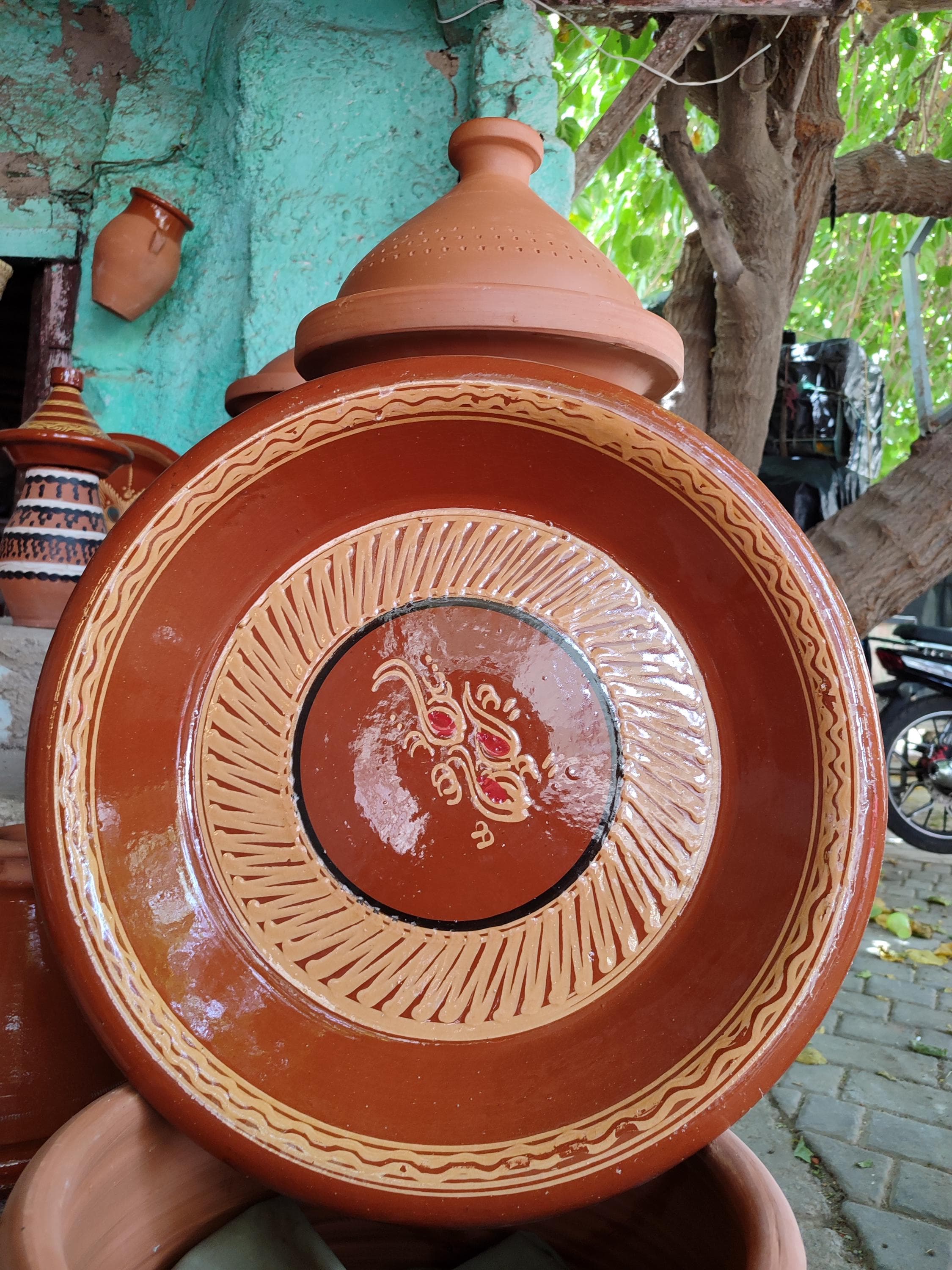 Experience authentic Moroccan cuisine with this traditional clay cooking pot. Expertly crafted as a Moroccan tangia or tajine, this handmade pottery vessel is designed for slow cooking, locking in flavor and tenderness. Made from natural, unglazed clay, this Moroccan cooking pot from Marrakech distributes heat perfectly for stews, couscous, and tagines. This cooking vessel is more than just Moroccan cookware; it's a piece of cultural heritage for your Moroccan kitchen
