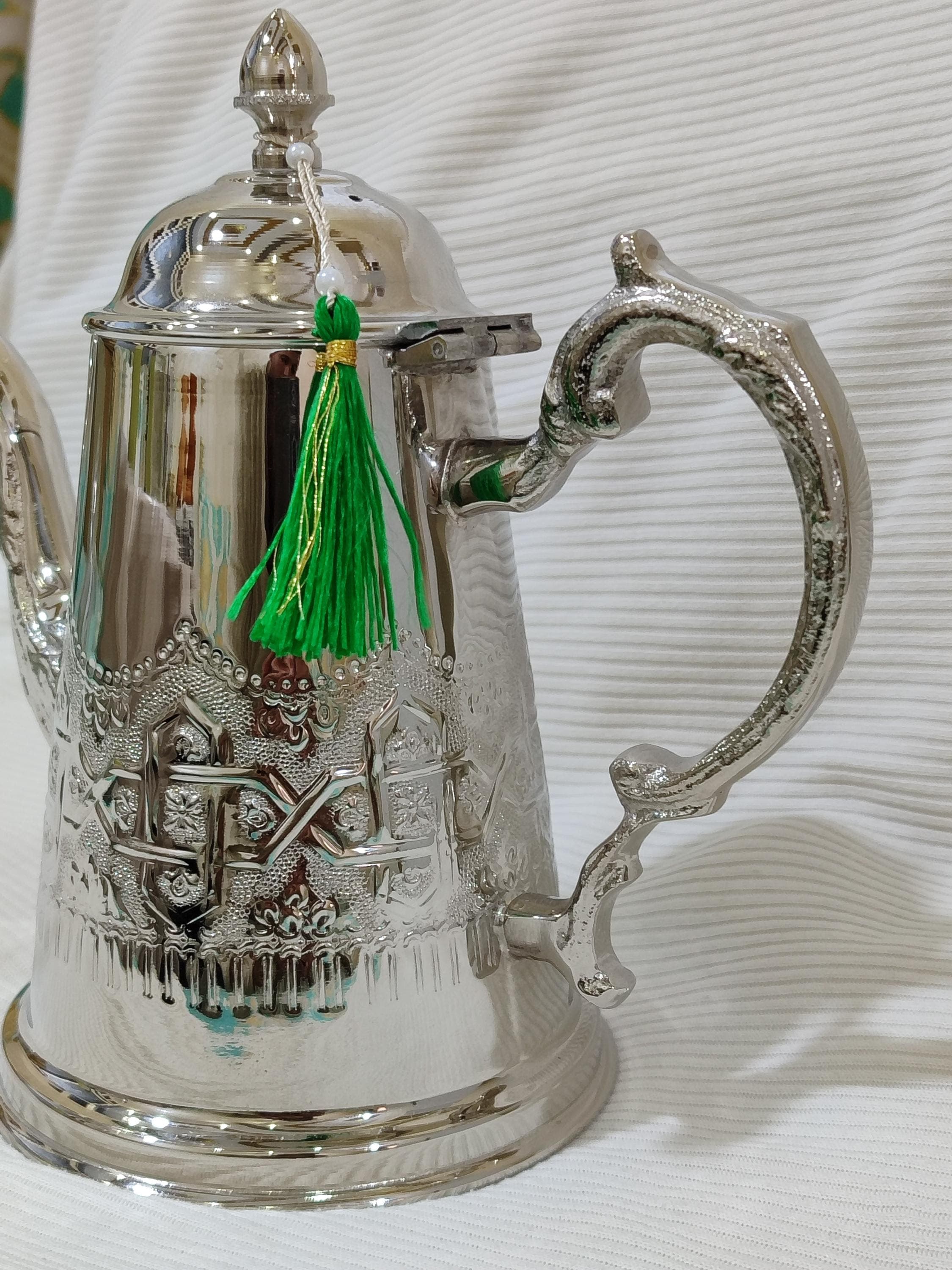 This authentic Berber teapot represents the rich cultural heritage of Morocco's indigenous communities. Handcrafted by skilled artisans, this traditional teapot features the distinctive rounded silhouette and detailed engraving that sets berber teapot designs apart. The silver teapot finish catches the light beautifully during tea ceremony gatherings, making it a stunning centerpiece for ramadan decor and eid celebrations.