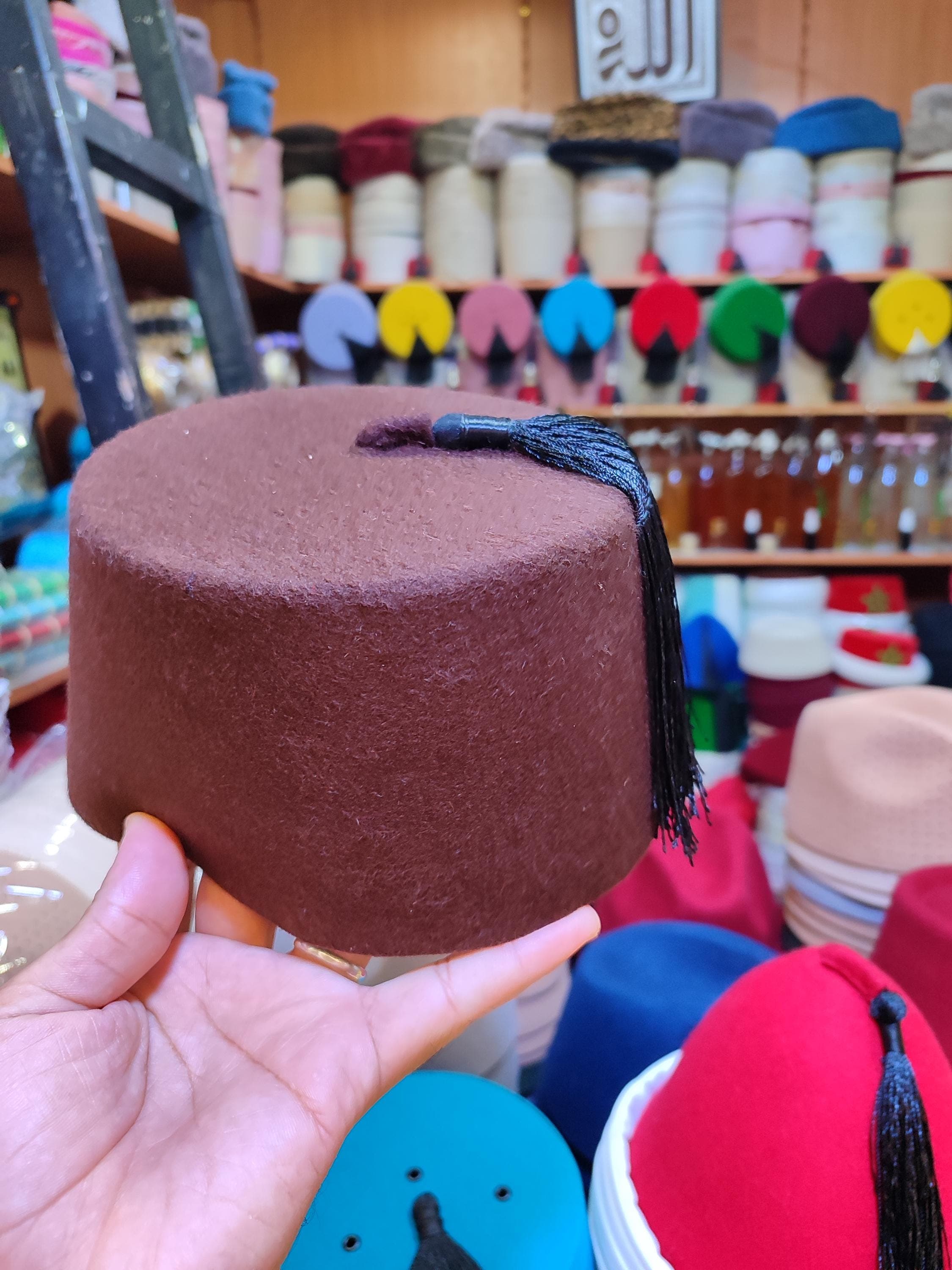 Embrace tradition with this iconic red hat fez, a symbol of Moroccan and Moorish heritage. Our tarboosh is handtailored using premium materials to ensure a perfect fit and durable finish. While we showcase the classic crimson, remember that custom colors are available to suit your preference. This Turkish fez hat design is loved worldwide and serves as a distinctive festival accessory or a sophisticated addition to formal wear. It’s more than a hat; it's a piece of cultural artistry.
