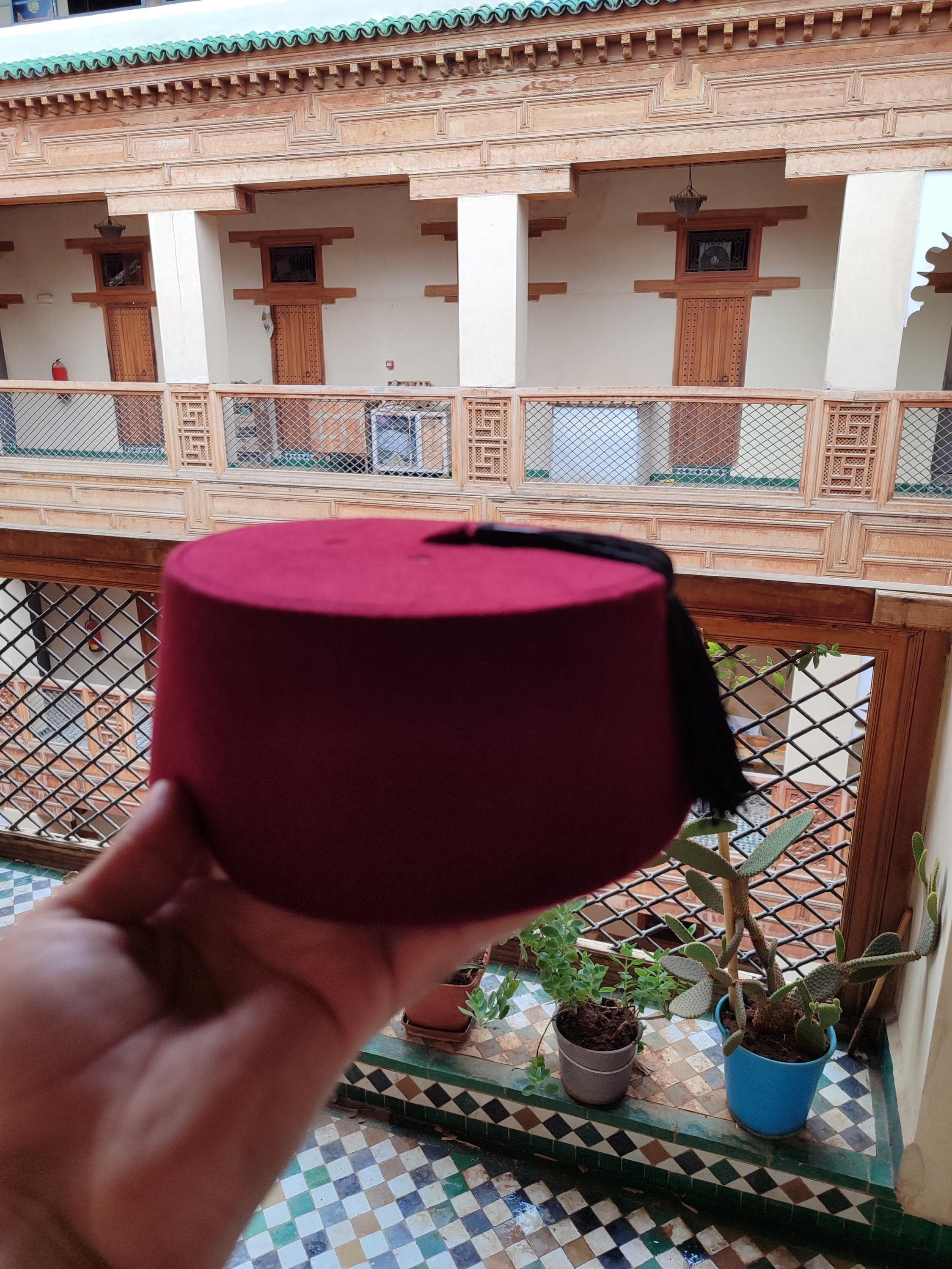 Discover the perfect blend of tradition and style with this premium Moroccan fez hat. Made from high-quality felt and adorned with a elegant custom silk tassel, this tarboosh is a standout festival accessory. Its deep burgundy hue and classic design pay homage to the Turkish fez hat tradition while offering modern versatility. Whether you're channeling Doctor Who inspired fashion or celebrating Moorish American culture, this handtailored hat is a conversation starter.