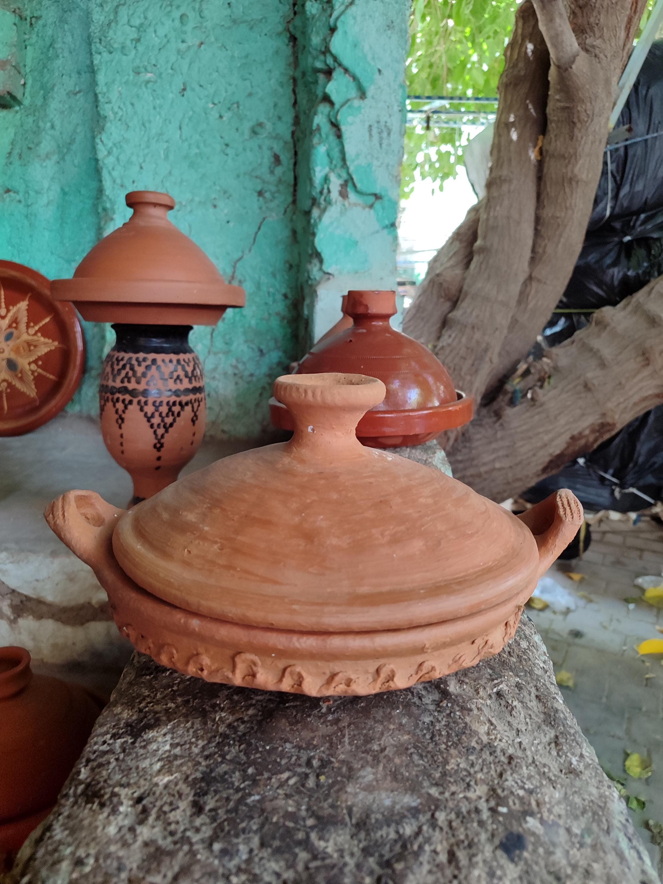 Our antique tagine pot recreates historic Moroccan tajine designs with authentic clay construction. This terracotta tagine features the iconic conical lid that perfectly circulates steam and condensation. Excellent for preparing classic Moroccan cooking favorites like lamb with prunes or vegetable tagines. The natural clay tajine material helps develop rich, deep flavors in every dish. A beautiful addition to any kitchen and wonderful traditional cookware for food enthusiasts.