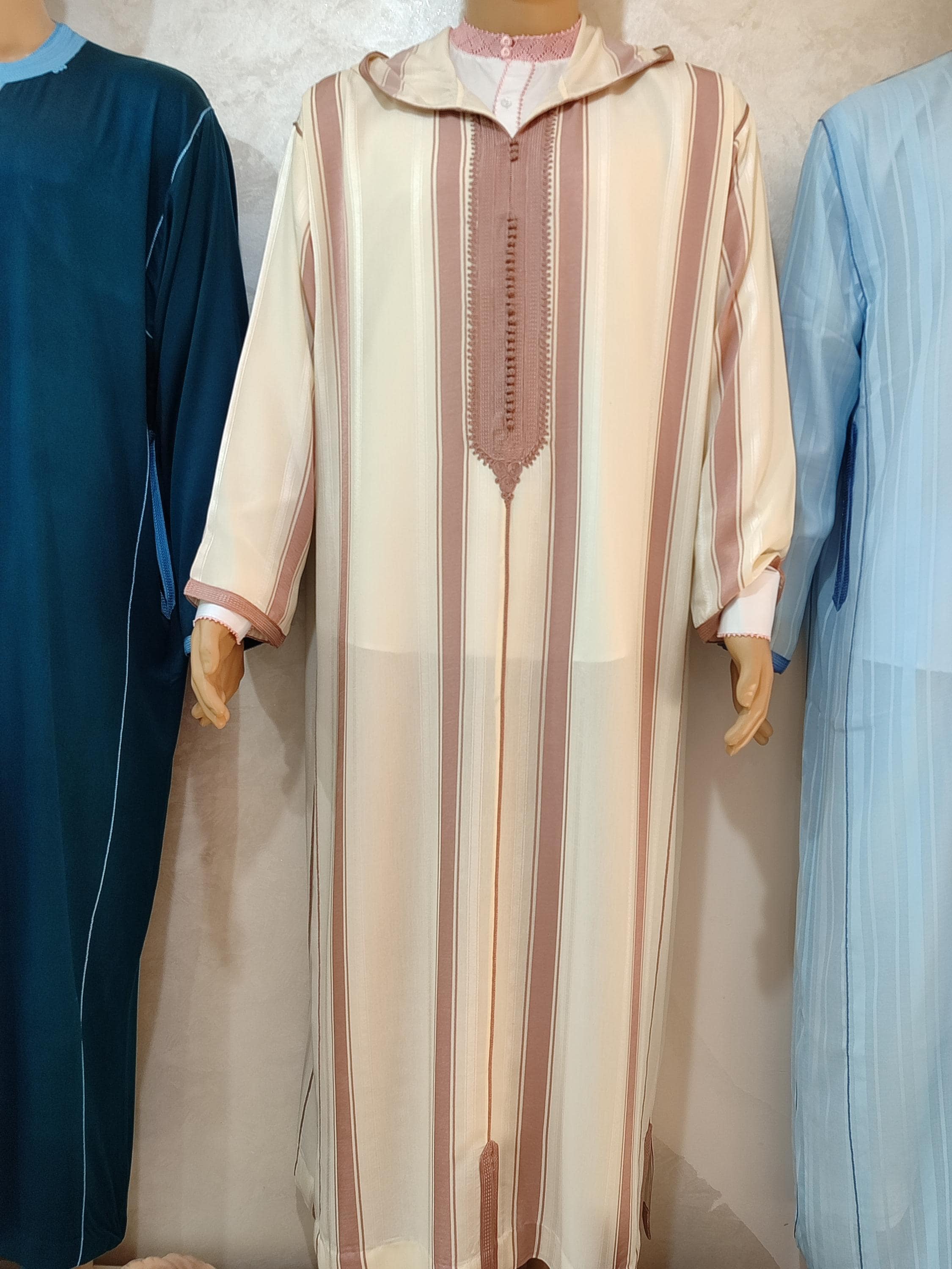Celebrate your special day in our exquisite nikkah thobe, a perfect nikah dress choice for the discerning groom. This hooded thobe for men is crafted from premium fabric, featuring intricate embroidery and a tailored fit for a regal appearance. As a central piece of Muslim men clothing, it offers both sophistication and comfort for your Islamic wedding ceremony. The elegant design also makes it suitable for Eid celebrations and other formal occasions. This Moroccan thobe is more than clothing