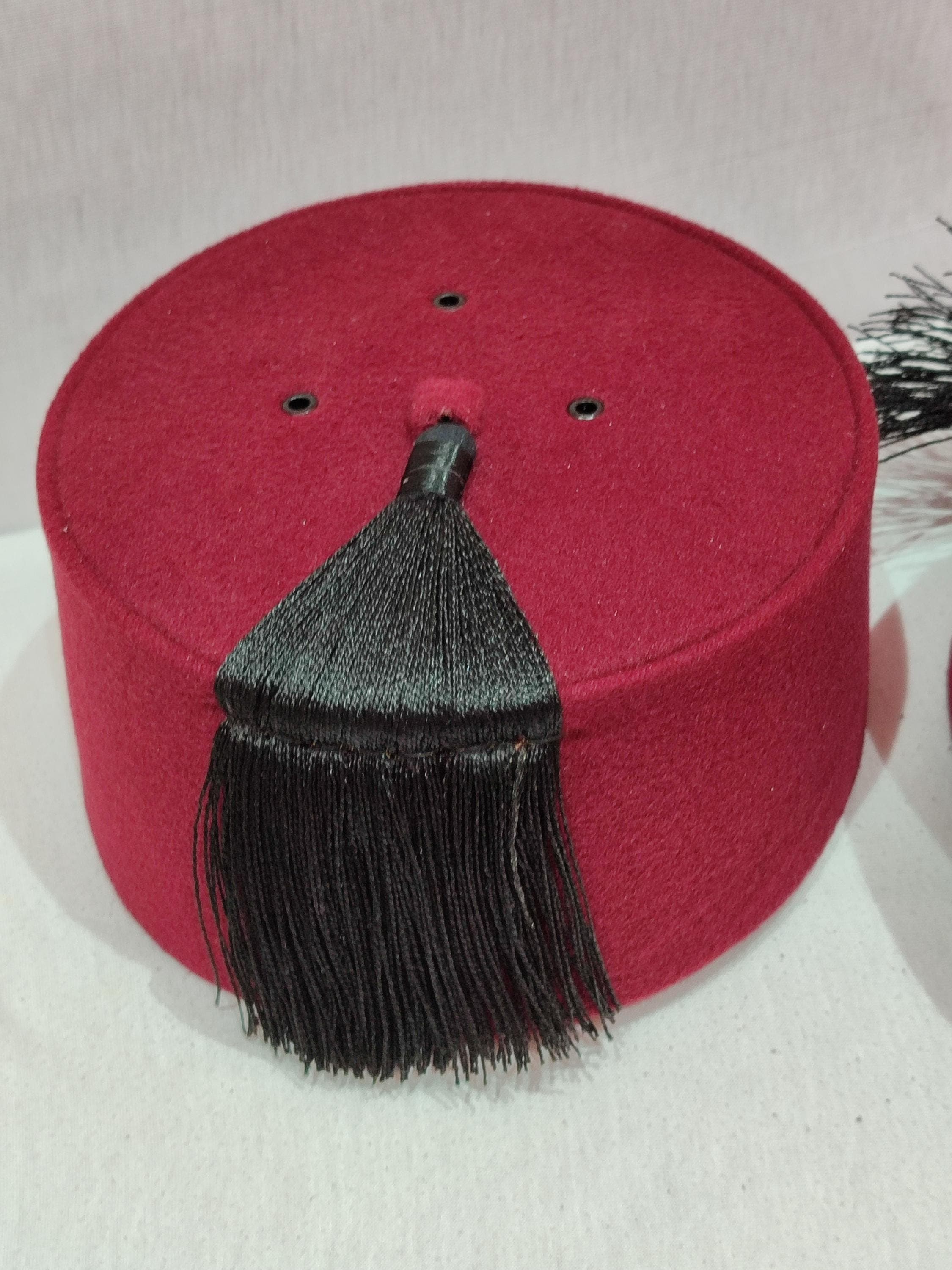 This authentic red fez embodies centuries of Moroccan heritage in its classic design. The tarboosh is meticulously crafted from high-quality wool felt and features the characteristic flat-topped shape with a black silk tassel. Whether you need a Halloween fez costume piece or seek to complete your Muslim turban collection, this Moroccan tarboush delivers both authenticity and style. The deep crimson color and elegant proportions make it suitable for theatrical performances,