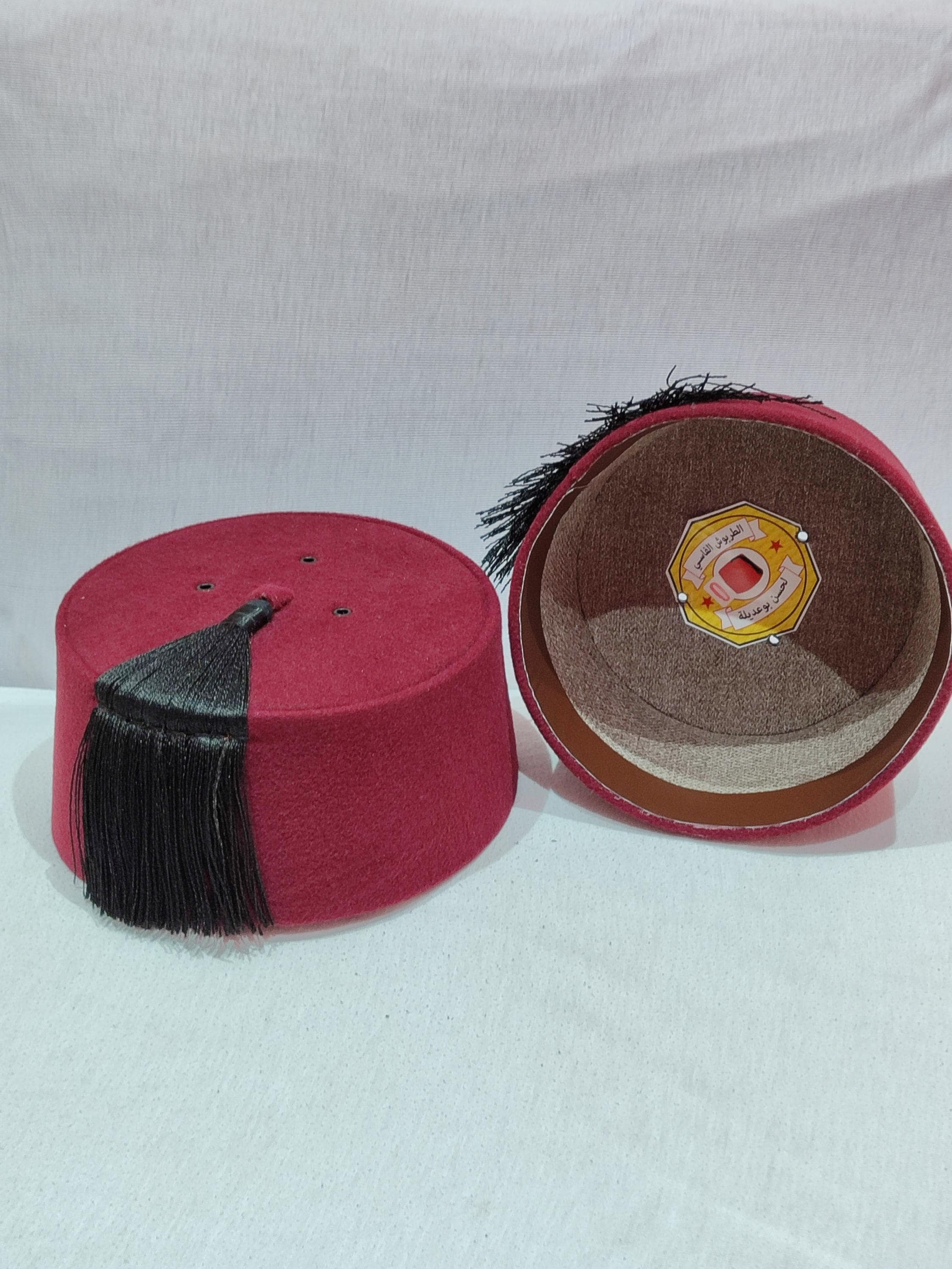 Experience royal sophistication with this royal tarboush handcrafted by skilled Moroccan artisans. This tarboosh hat features luxurious burgundy velvet adorned with intricate gold embroidery and a sleek silk tassel. Perfect for completing costume fez outfits or adding authenticity to Muslim turban styles, this Moroccan fez combines traditional design with modern comfort. The adjustable inner band ensures a perfect fit for various head sizes, making it an ideal accessory for formal events
