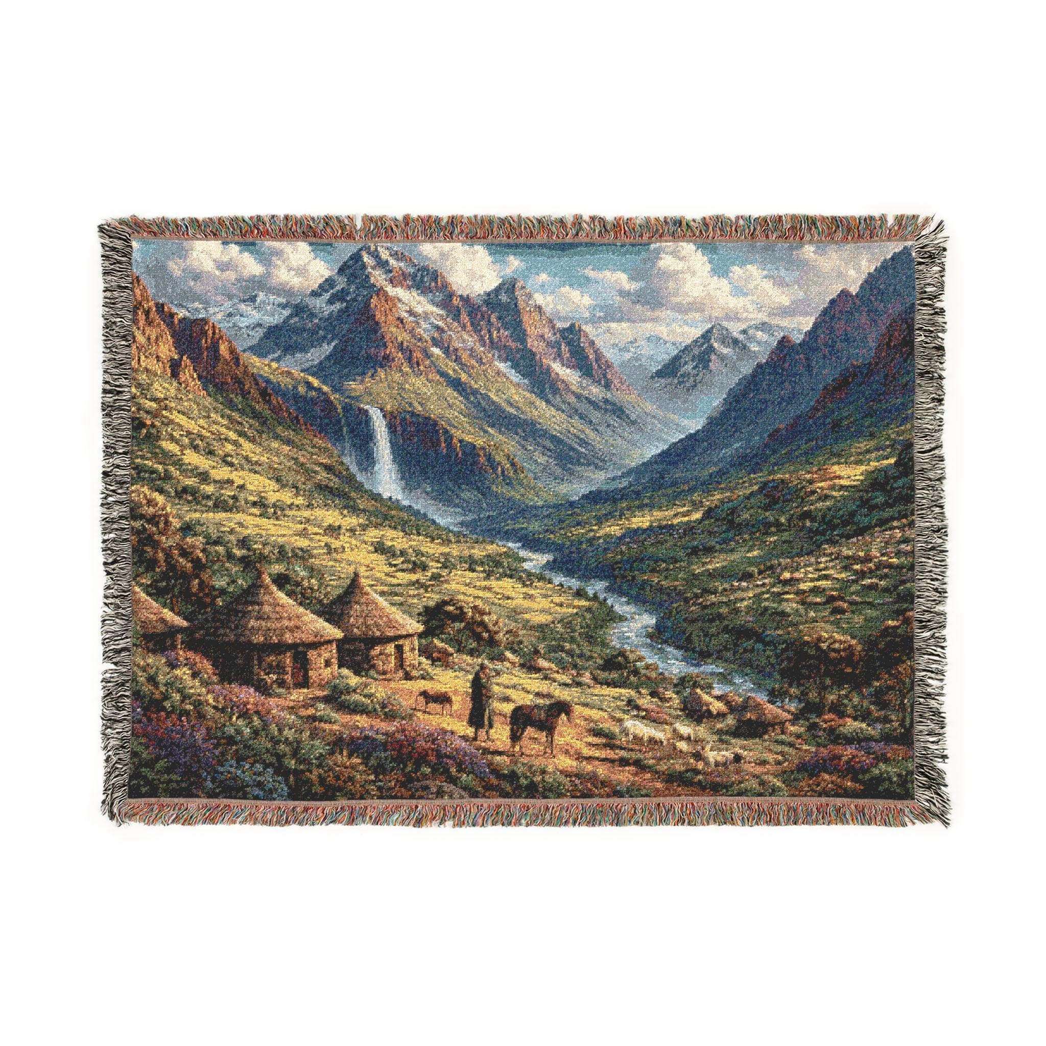 Woven tapestry wall hanging with fringe featuring a dramatic mountain valley landscape: rugged peaks, a tall waterfall, winding river, wildflower meadow, and cozy huts with horses in the foreground. Rustic lodge cabin decor vibe with warm sunlit greens and golden tones, perfect as scenic wall decor for living room, bedroom, office, or cabin. Also works as a cozy woven throw blanket. Great gift for hikers, campers, backpackers, travel lovers, and nature photographers.