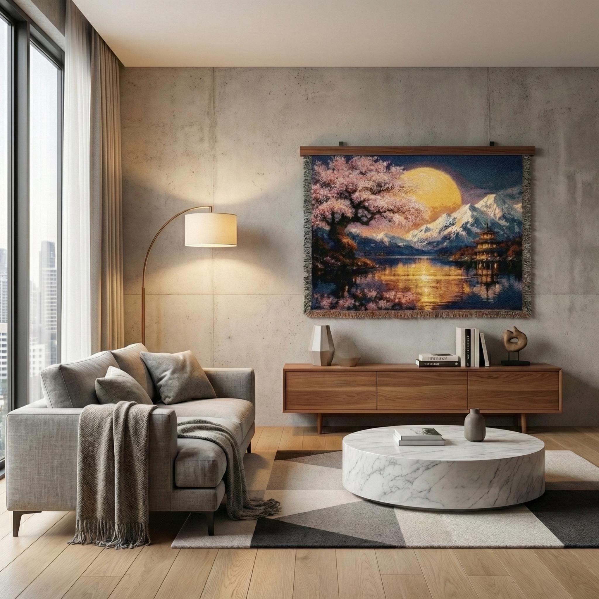 Woven tapestry blanket featuring a Japanese-inspired night landscape with pink cherry blossoms, a large golden moon, snowy mountains, and a pagoda beside a calm lake with shimmering reflections. Deep blue sky and warm light create a serene, zen mood. Fringed edges and detailed woven texture make it ideal as tapestry wall art, wall hanging, or cozy throw for bedroom, living room, reading nook, meditation space, or Asian-inspired home decor.